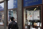Chodkyně si prohlíží výlohu knihkupectví Academia